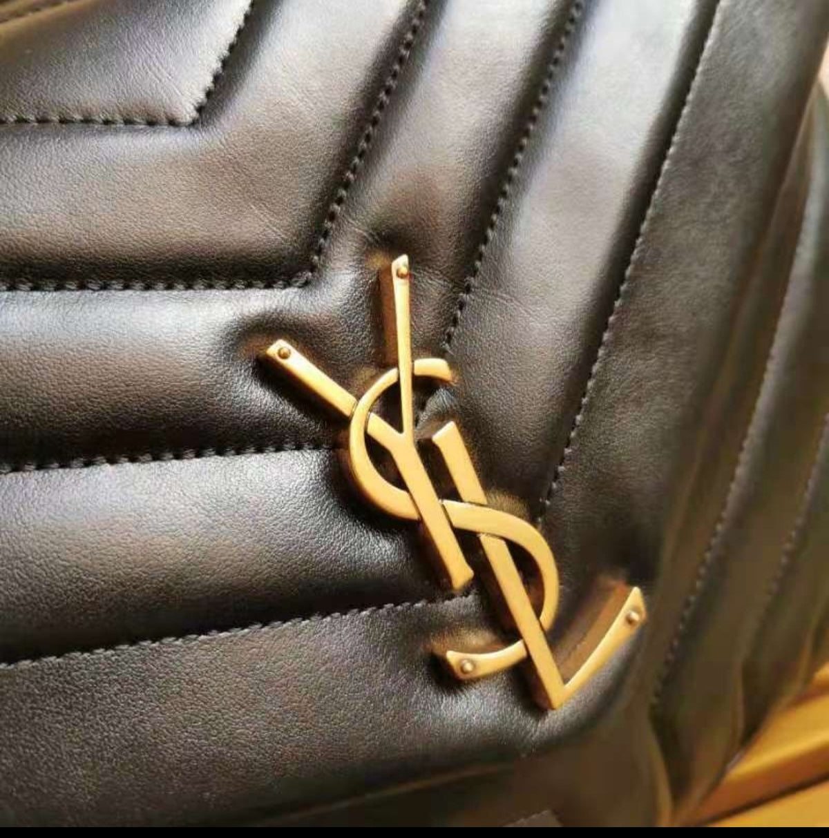 Yves Saint Laurent Loulou Toy preta, em pele matelassé, com ferragens douradas envelhecidas.